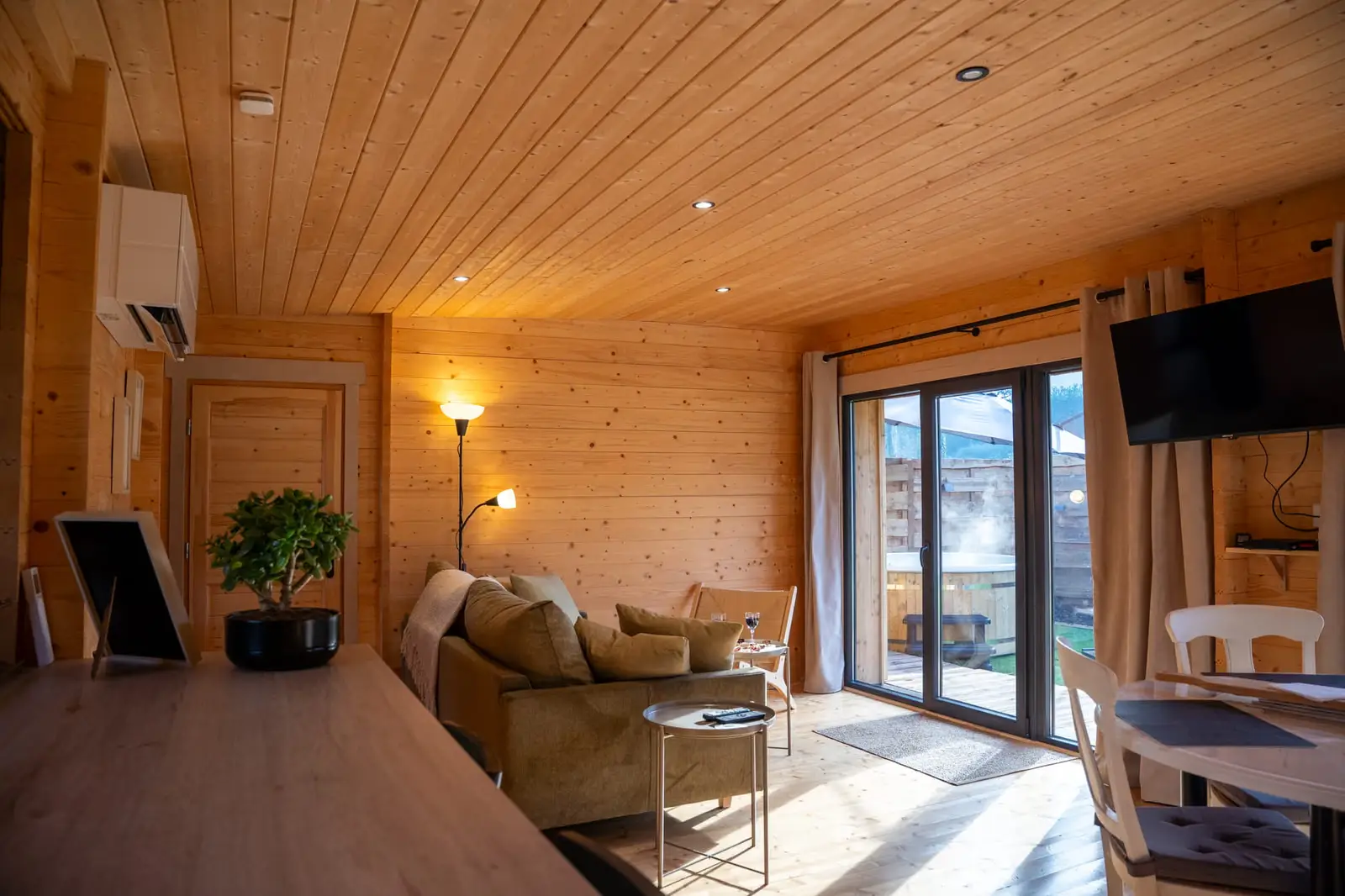 Salon en bois du gîte Ò Chalet à Camors ouvrant sur le spa extérieur